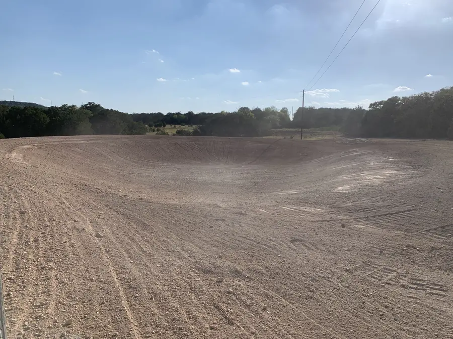 Wide graded basin with a tree line behind