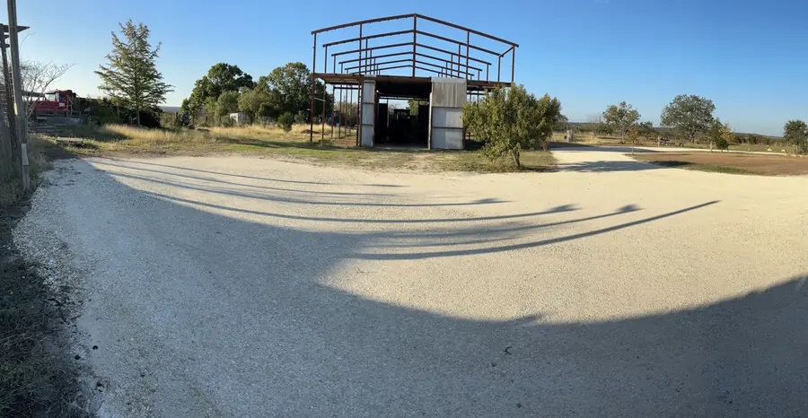 Wide pale gravel apron in front of a steel building frame