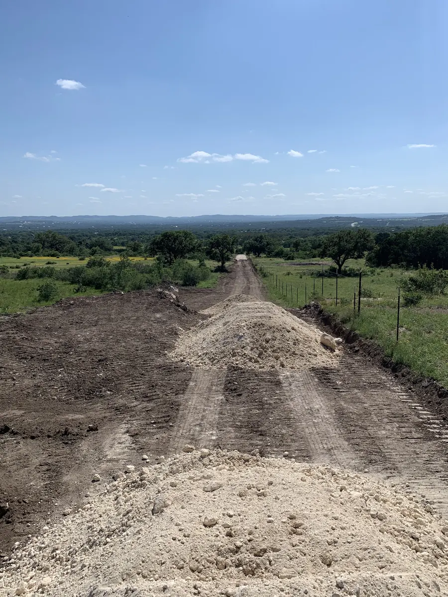 New road cut running downhill, with a pile of fresh fill in the foreground